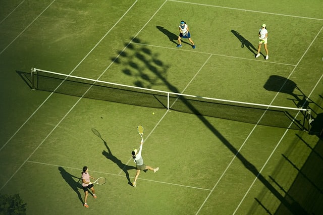 four player playing tennis on a court